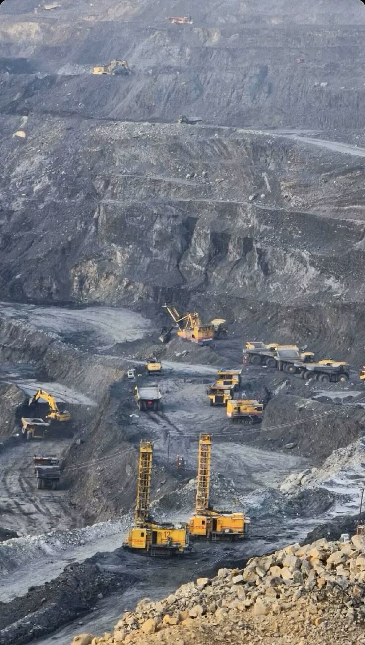 Open-pit mine with haul trucks and drilling rigs